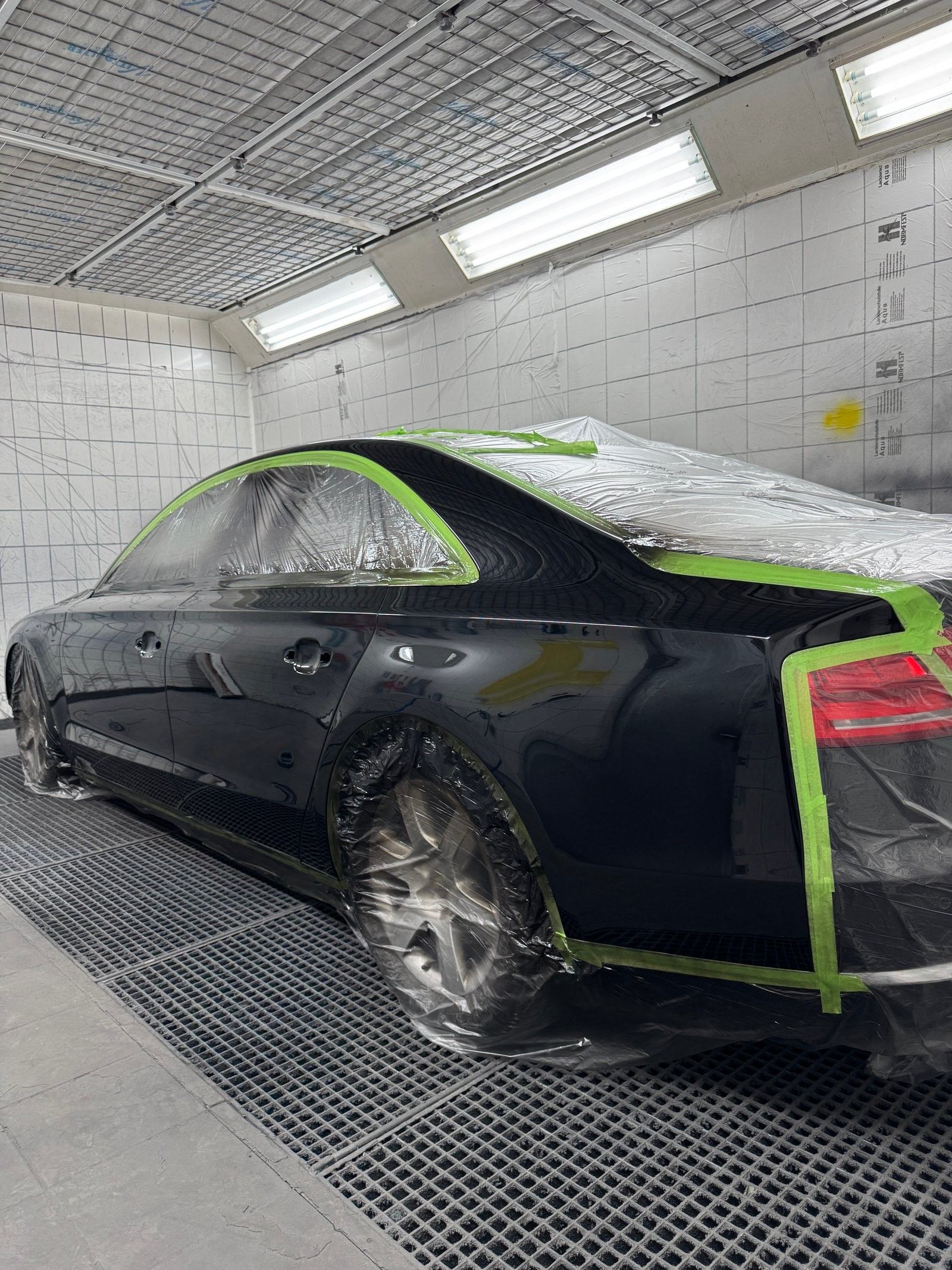 Abgeklebter Audi in der Lackierkabine, vorbereitet für die Lackierung