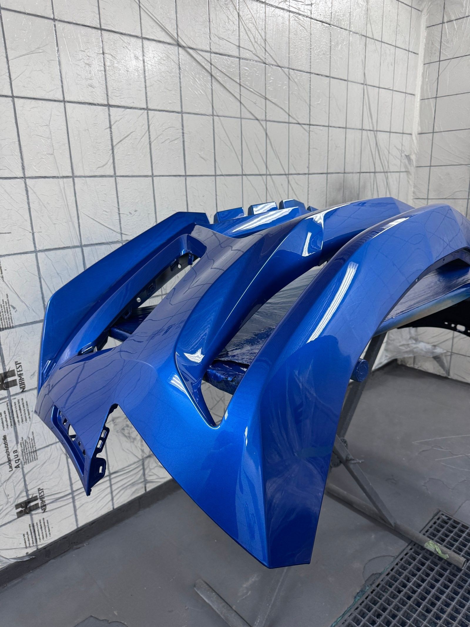 Frisch lackierte blaue Stoßfänger in der Lackierkabine